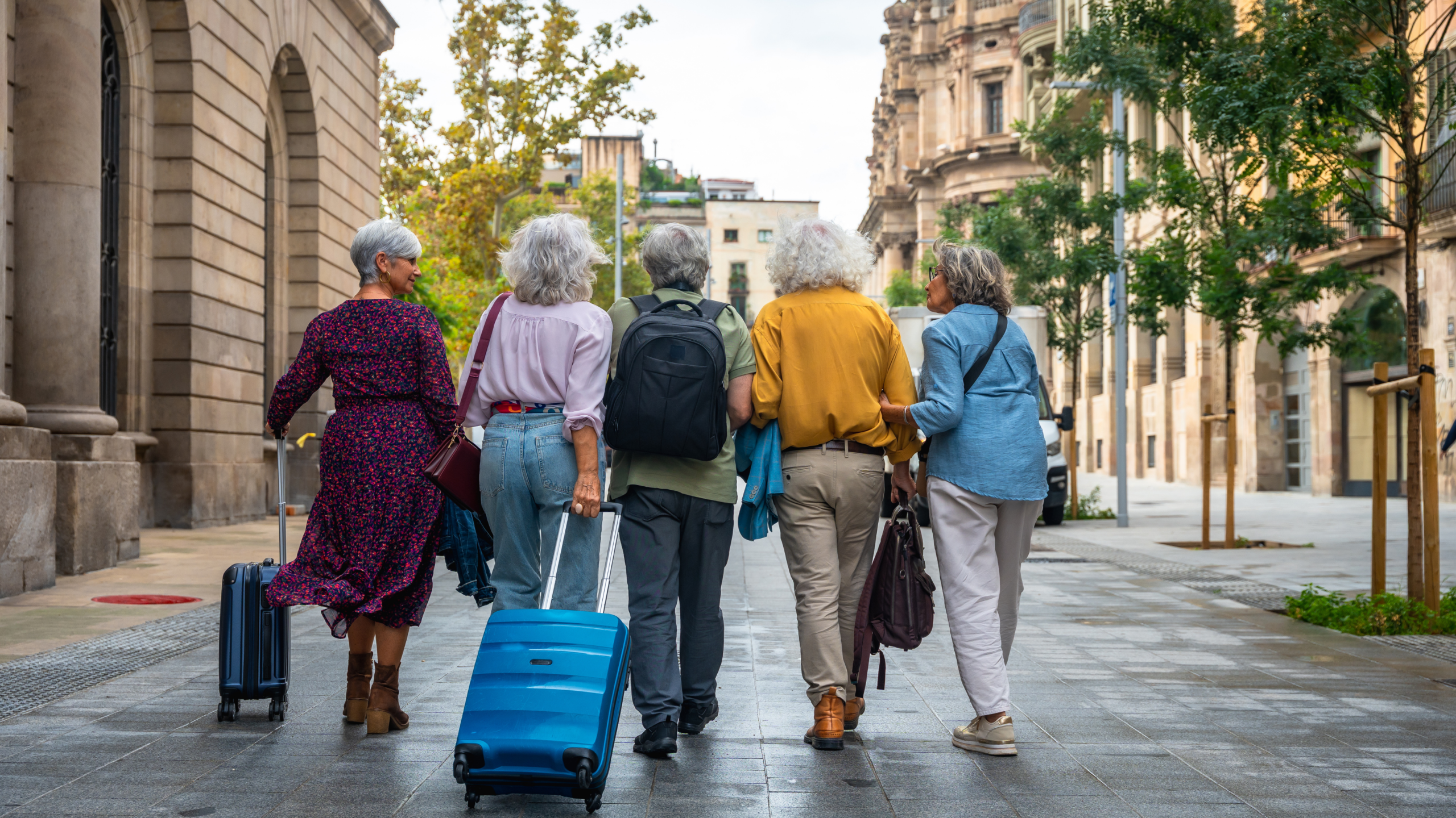 Five women walking together down a street having a great time